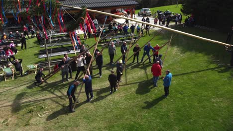 Men-raising-mlaj-maypole-using-wooden-sticks--Community-group-members-working-together-the-Mlaj