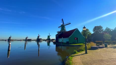 Windmills-in-a-row-across-the-river-Zaans-in-Zaanse-Schans,-Netherlands