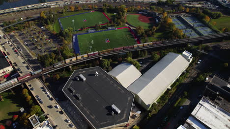 Aerial-view-tracking-a-cargo-train,-revealing-the-skyline-of-Philadelphia,-USA