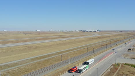 Langsames-Drohnenvideo-Des-Internationalen-Flughafens-Denver-Mit-Straße-Und-Autos-Im-Vordergrund
