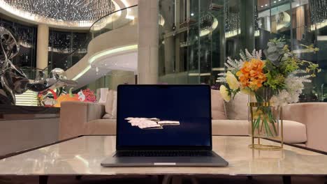 Laptop-Displaying-Paper-Bills-on-a-Marble-Table-Inside-a-Luxurious-Mansion