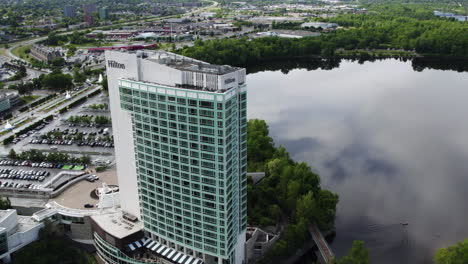 Aerial-view-orbiting-the-Hilton-Hotel-at-lake-Lac-Leamy,-in-Gatineau,-Canada