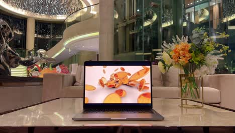 Laptop-on-a-Marble-Table-Displaying-Falling-Gold-Coins-Inside-Luxurious-Mansion