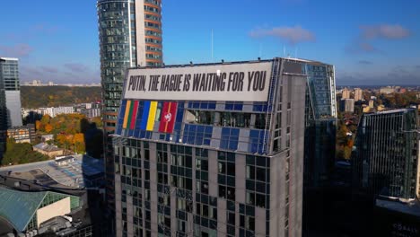 Putin-the-Hague-is-waiting-for-you-anti-war-protest-sign-on-business-skyscraper