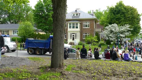 Polizisten-In-Kampfausrüstung-Stehen-In-Einem-Vorstadtpark,-Während-Scharen-Von-Fußgängern-Zuschauen