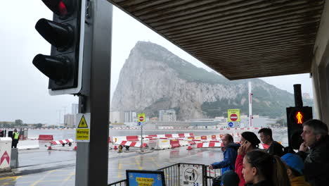 Gente-Esperando-En-El-Cruce-De-Carreteras-Del-Aeropuerto-De-Gibraltar-En-Un-Día-Lluvioso