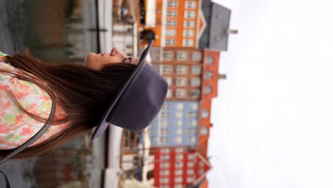 Woman-with-hat-enjoying-colorful-buildings-of-Nyhavn-with-seagulls-flying-over-water