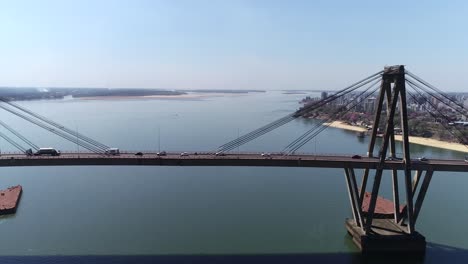 Aerial-drone-shot-panning-over-the-Manuel-Belgrano-Bridge-in-Corrientes,-displaying-heavy-traffic-flow