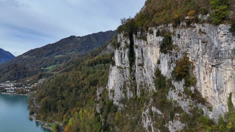Aerial-approaching-shot-of-rocky-cliffs-at-Lake-Walen-during-cloudy-day-in-Switzerland