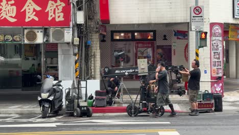 Professional-videographers-carefully-handle-the-camera-types-of-equipment-while-filming-in-Ximending,-Taipei,-Taiwan