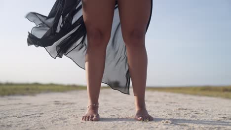 Latina-Frauen-Mit-Schwarzem-Kleid-Im-Wind-Auf-Sand-Auf-Der-Insel-Coche,-Venezuela