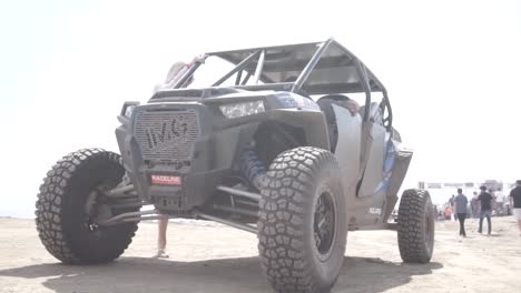 Un-Hombre-Y-Una-Mujer-Rubia-Montando-Un-Buggy-De-Rally-En-Una-Carrera-De-Rally-Raid