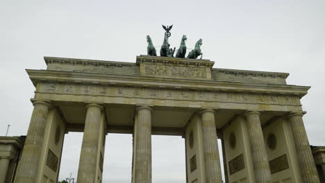 Toma-En-Primera-Persona-Caminando-Frente-A-La-Estatua-De-La-Cuadriga-En-La-Puerta-De-Brandenburgo-En-El-Nublado-Berlín.