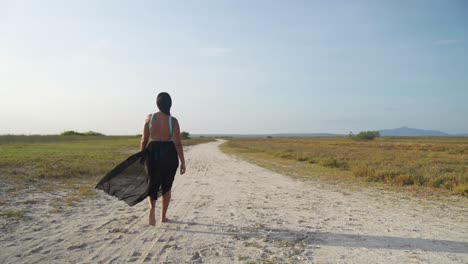 Latina-walking-in-slow-motion-in-the-sand-on-Coche-Island,-Venezuela