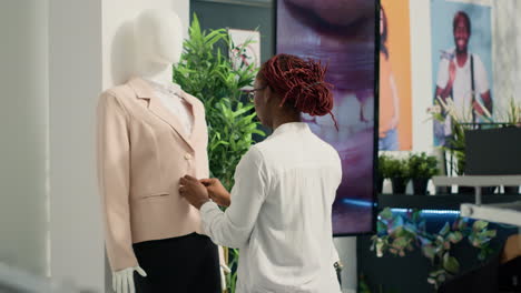 Retail-clerk-arranges-mannequin-blazer