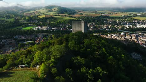 Large-aerial-view-of-Crest-and-the-Tower-during-sunshine-day,-a-town-in-the-Drôme,-region-of-Auvergne-Rhône-Alpes,-France