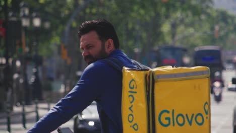 Glovo-food-delivery-person-on-the-streets-to-deliver-food,-Barcelona,-Spain