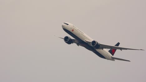 Un-Primer-Plano-De-Un-Boeing-777-De-Air-Canada-En-Pleno-Vuelo,-Inclinándose-Después-De-Despegar-Del-Aeropuerto-Internacional-Pearson,-Canadá