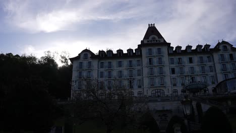 Palace-de-Menthon-luxury-hotel-in-the-French-Alps-at-dusk,-Wide-dolly-right-shot