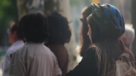 Girl-with-protective-helmet-on-scooter-waiting-for-traffic-light-in-city-to-cross