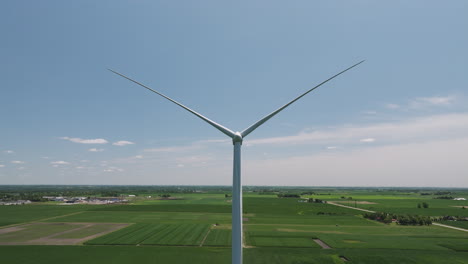 Vista-Panorámica-De-Turbinas-Eólicas-Sobre-Campos-De-Maíz-Verde-En-Crecimiento-En-Iowa,-Estados-Unidos