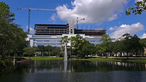 Fountain-in-lake-outside-Mayo-building-at-the-Mayo-Clinic-in-Jacksonville-Florida-with-building-and-construction-in-the-background