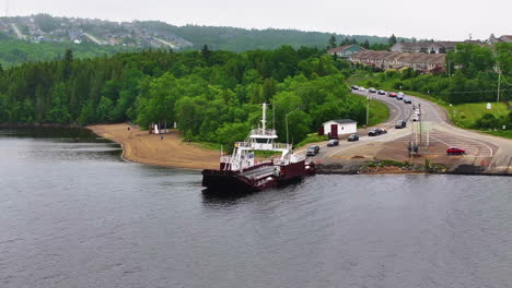 Aerial-view-of-cars-lined-up-and-driving-on-to-a-ferry