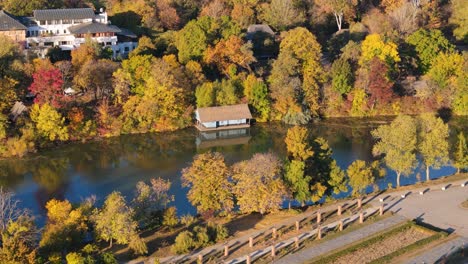 Rotating-Drone-View-Of-A-Small-House-On-Lake-Herastrau-In-Bucharest,-Romania,-Autumn