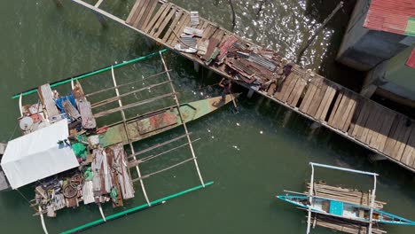 Top-down-Aerial-of-man-unloading-salvaged-scrap-metal-off-outrigger