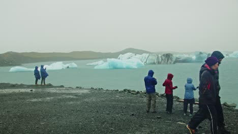 Tourists-looking-at-Lake-Jokulsarlon-in-Iceland-and-walking-around