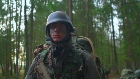 Close-up-of-NATO-soldiers-with-make-up-and-camouflage-in-forest-steadicam