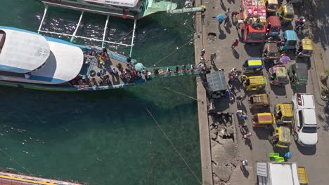 Vista-Aérea-De-Arriba-Hacia-Abajo-De-Personas-Descargando-Desde-Un-Barco-De-Isla-En-Isla