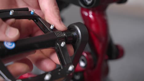 Hand-installing-flat-pedal-with-pegs-into-crank-arm-of-brand-new-mountain-bike-by-bycicle-mechanic
