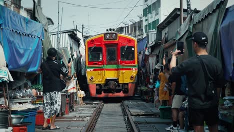 Low-Angle-View-of-Train-Arrival-at-Maeklong-Market-in-Thailand