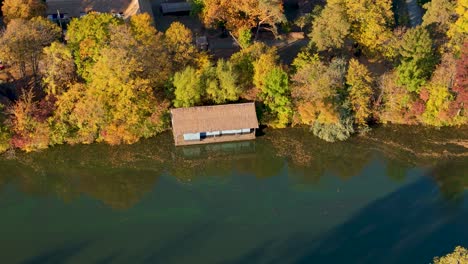 Slow-Aerial-Reveal-Of-A-Small-House-On-Lake-Herastrau-In-Bucharest,-Romania,-Autumn