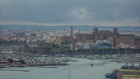 Eine-Große-Stadtlandschaft-An-Der-Küste-Und-Weiße-Boote,-Die-Im-Meer-Auf-Malta-Segeln