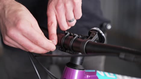 Process-of-fastening-handlebar-to-bike-stem,-hand-turning-screws-gently-by-bicycle-mechanic