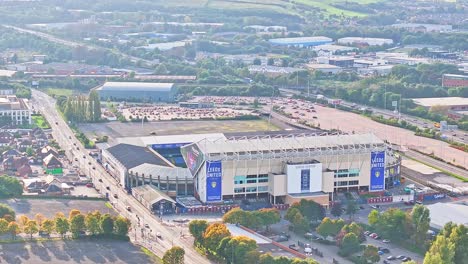 Vista-Aérea-Del-Estadio-Elland-Road-De-Leeds-United-Durante-El-Día-Soleado-Y-El-Tráfico-En-La-Autopista-En-Inglaterra