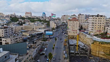 Aerial-Towards-Palestinian-Flag-Along-City-Street-In-Hebron,-Palestine