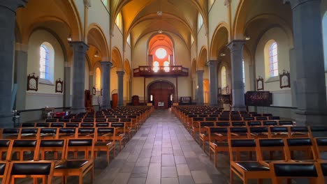 Row-of-black-chairs-for-prayer-inside-Roman-Catholic-church-in-Neerpelt-Belgium