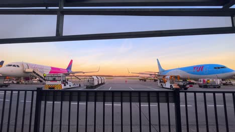 Aviones-De-Wizzair-Y-Tui-Esperando-Pasajeros-Frente-A-La-Terminal-En-Tierra