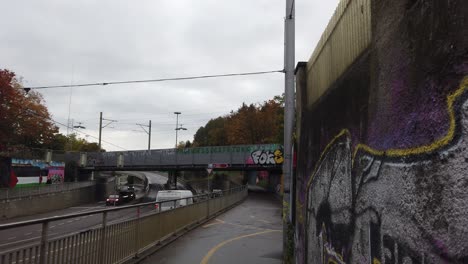 Graffiti-Arte-Callejero-Debajo-De-Un-Puente-En-Berna,-Suiza,-Automóviles-Circulando-Por-La-Carretera.