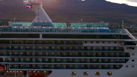 Cruise-ship-docked-near-Icelandic-town-with-mountain-backdrop