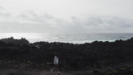 Woman-tourist-exploring-Ponta-da-Ferraria's-rugged-coastline-in-Azores