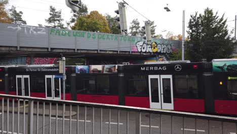 El-Tranvía-Rojo-Cruza-Un-Puente-Con-Graffiti-En-El-Barrio-De-Bumpliz,-Berna,-Suiza.