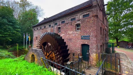 Water-mill-wheel-turning-around-quickly-giving-energy-in-historic-castle-garden
