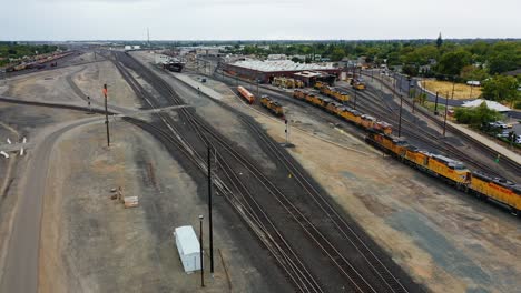 Aerial-view-rotating-over-train-yard-of-Roseville,-cloudy-California,-USA