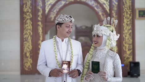 Bride-and-Groom-holding-buku-nikah-or-the-marriage-book-at-wedding-procession