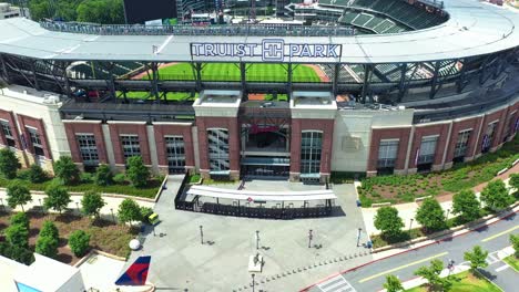 Aerial-backwards-shot-of-Truist-Park-baseball-stadium-in-Atlanta-City-during-sunny-day---Drone-Establishing-shot