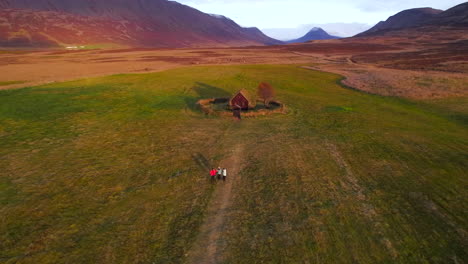 Turistas-Asiáticos-Visitando-La-Iglesia-De-Césped-Grafarkirkja-En-El-Norte-De-Islandia-Al-Atardecer